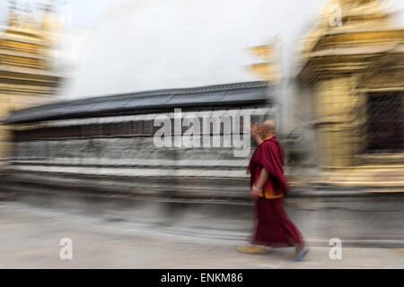 Il Tibetano monaco buddista a piedi dalle ruote della preghiera a Swayambhunath o Monkey Temple Kathmandu in Nepal Foto Stock