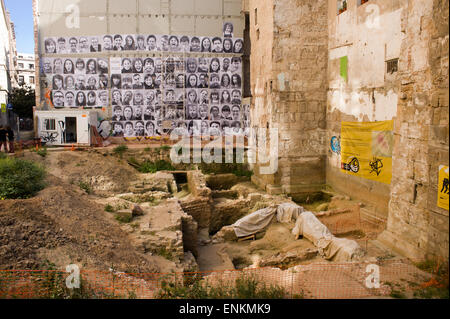 Foto di volti di persone locali della parte vecchia di Barcellona sono vedere appeso accanto alle mura storiche della città. Foto Stock