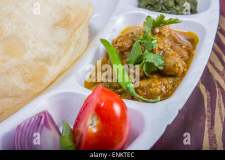 Spicy chole bhautre, con peperoncino verde topping, e insalata, piatto indiano Foto Stock