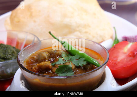 Spicy chole bhautre, con peperoncino verde topping piatto indiano Foto Stock