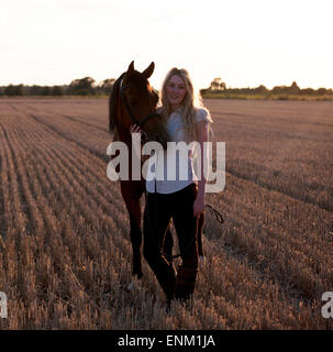 Una giovane donna in piedi con un cavallo arabo Foto Stock