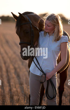 Una giovane donna guardando un cavallo arabo Foto Stock