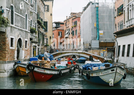 Operai consegna delle merci da imbarcazioni a Venezia Foto Stock