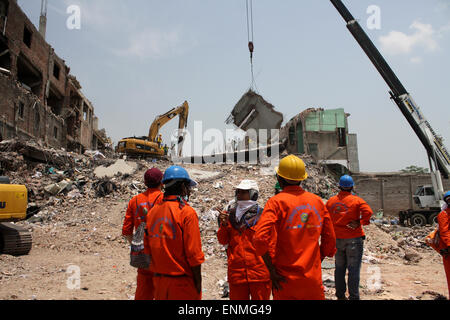 Bangladesh soccorritori look per i superstiti e vittime in corrispondenza del sito di un edificio che è collassata in Savar, vicino a Dacca in Bangladesh. Foto Stock