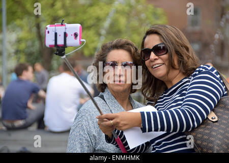 Due donne turisti prendendo un selfie vicino alla fontana di Washington Square Park nel Greenwich Village di New York City Foto Stock