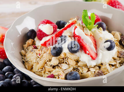 Sana colazione con maturi frutti di bosco freschi, yogurt e muesli. Messa a fuoco selettiva Foto Stock