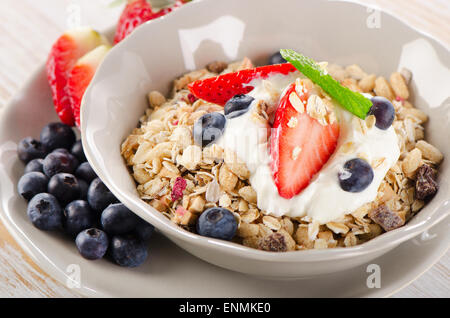 Sana colazione con bacche mature, yogurt e muesli. Messa a fuoco selettiva Foto Stock