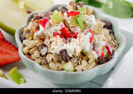 Muesli, yogurt e frutta a colazione in una ciotola. Messa a fuoco selettiva Foto Stock