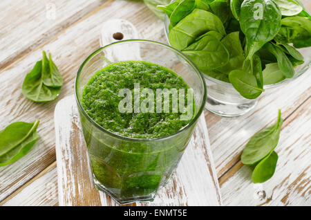 Frullato di spinaci in vetro su sfondo di legno. Foto Stock