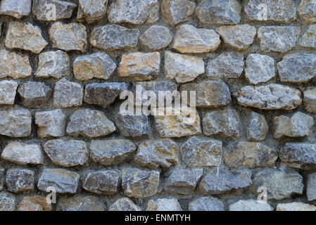 Un muro fatto di molte piccole pietre quadrate. Foto Stock