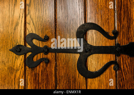 Pesante ferro cerniera su una vecchia porta di legno. Foto Stock