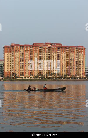 Un motore di lancio, o canoa, passando edifici alti in Ernakulam's waterfron. Foto Stock