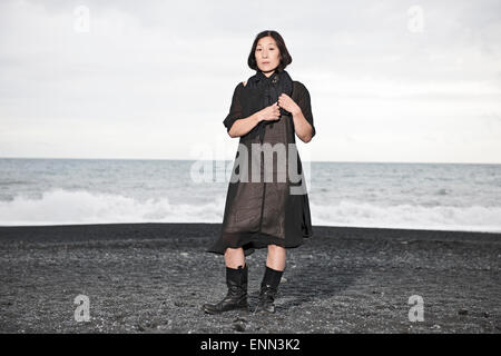 Il coreano donna in piedi sulla spiaggia di sabbia nera Foto Stock