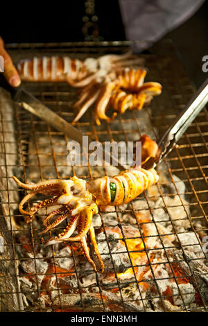 Calamari su un barbeque a un mercato di strada in Thailandia Foto Stock