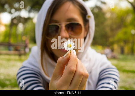 Bruna ragazza con margherite nel parco Foto Stock