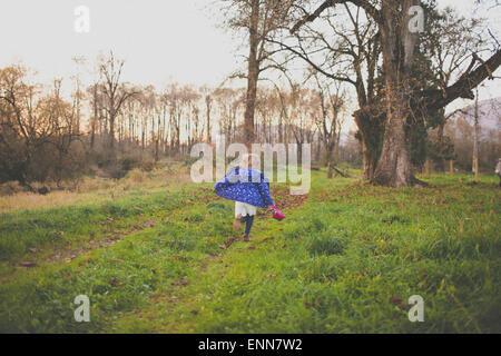 Una giovane ragazza scorre attraverso un grassy archiviato. Foto Stock