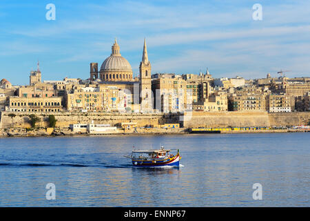 Il tradizionale maltese Luzzu barca per crociere di turisti e vista sulla Valletta Sliema Malta Foto Stock