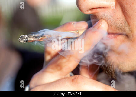 Close up, uomo fumare marijuana joint, la cannabis Foto Stock