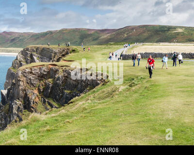 Walkers lungo le cime della scogliera a Rhossili Bay, Gower, Galles Foto Stock