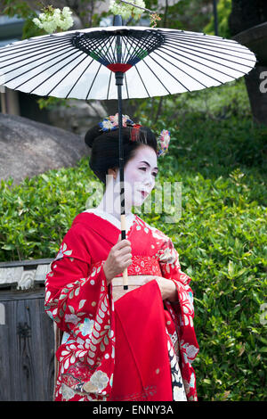 Geisha in abbigliamento tradizionale e olio-ombrello di carta (wagasa) a Kyoto, Giappone Foto Stock