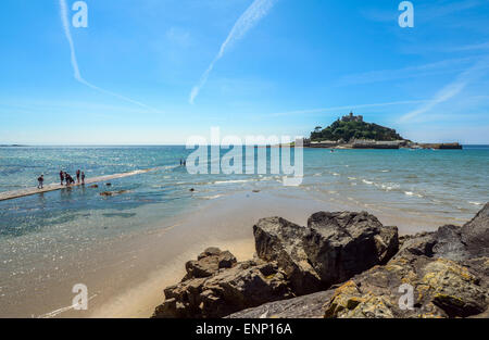 I vacanzieri di attendere per la marea di cadere in modo da poter attraversare a St Michael's Mount in Cornovaglia Foto Stock