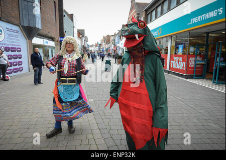 Morris uomini, uno vestito come una donna chiamata Betsy e gli altri in un costume di Drago, intrattenere gli amanti dello shopping nella città di Horsham West Sussex, in Inghilterra durante la Broadwood Morris uomini Giorno della Danza 2015. Foto Stock