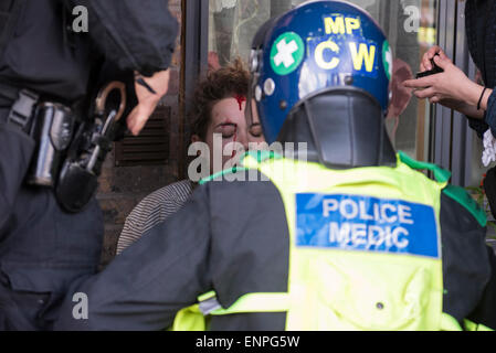 Una giovane donna è frequentato da medici poilce dopo essere stato colpito da un missile a difesa inglese League marzo in Walthamstow. Foto Stock