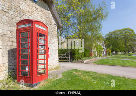 Red K6 nella casella Telefono in un villaggio rurale, England, Regno Unito Foto Stock