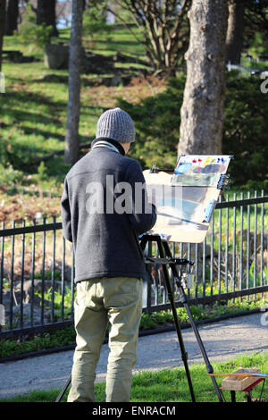 Un artista maschile la pittura nel parco. Foto Stock