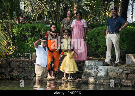 Un raduno di famiglia sulla riva del fiume Pampa, il terzo fiume più lungo di 110 miglia nelle acque del Kerala, India Foto Stock