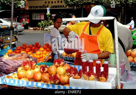 Bangkok, Thailandia: uomo nel suo carrello di alimentare la vendita di spremuta di succo di melograno su strada Yaoworat a Chinatown Foto Stock