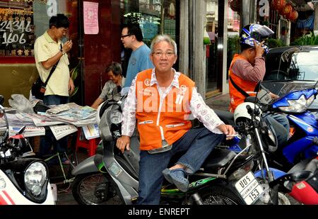 Bangkok, Thailandia: moto taxi driver seduto sulla sua moto in attesa di un passeggero sulla strada Yaoworat a Chinatown Foto Stock