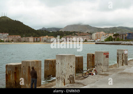 Un uomo e la sua bicicletta nel solarium villaggio di pescatori di Castro Urdiales, Cantabria, Spagna, Europa. Foto Stock