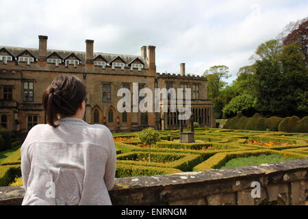 Donna che guarda oltre lo spagnolo giardino murato a Newstead Abbey Foto Stock