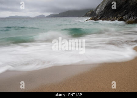 Onde lambisce la sabbia in spiaggia Coumeenoole sulla penisola di Dingle, Irlanda. Foto Stock