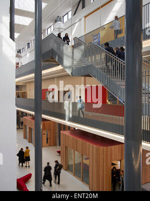 Vista obliqua verso la tromba delle scale interne con gli studenti in movimento. Regent High School di Londra, Regno Unito. Architetto: Walters Foto Stock