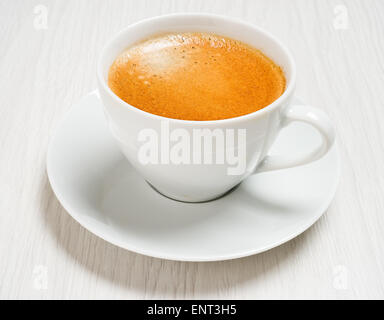 Caffè lungo in una tazza bianca su un tavolo, primo piano Foto Stock