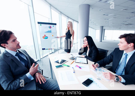 Imprenditrice che mostra i dati su whiteboard Foto Stock