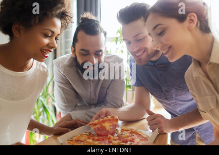 Happy business team di mangiare la pizza in ufficio Foto Stock