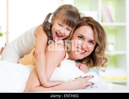 Felice la madre e il bambino ragazza divertirsi in camera da letto Foto Stock