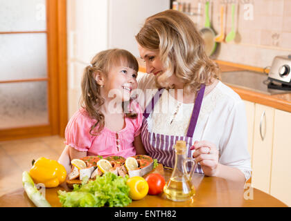 Madre e figlia cook e comunicare in cucina a casa Foto Stock