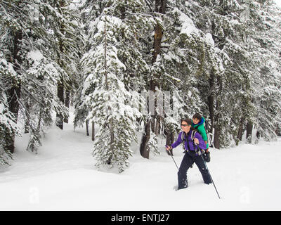 Madre e figlio di fare escursioni con le racchette da neve Foto Stock