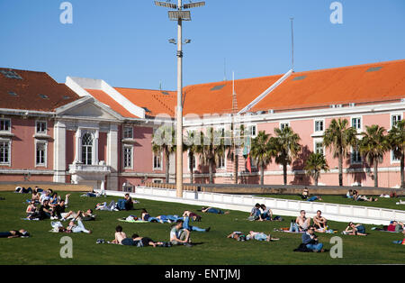 Persone rilassante sul terrapieno di erba a Doca da Caldeira in Lisbona - Portogallo Foto Stock