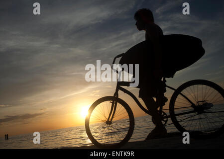Un surfista cavalca una bicicletta di Holbox, Quintana Roo, la penisola dello Yucatan, Messico Foto Stock