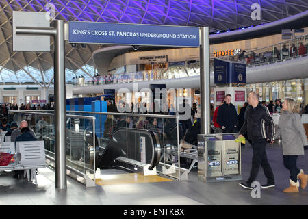 Scale mobili finoal sotterranea del concourse alla stazione ferroviaria di King's Cross, London Regno Unito Foto Stock