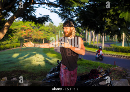 L'uomo la preparazione per cavalcare su un longboard skate, Bali, Indonesia. Foto Stock