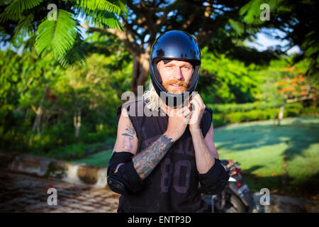 L'uomo la preparazione per cavalcare su un longboard skate, Bali, Indonesia. Foto Stock