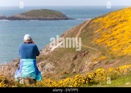 Fotografo che scatta foto al promontorio di Porthclais vicino a St Davids al Pembrokeshire Coast National Park, Galles UK, a maggio Foto Stock