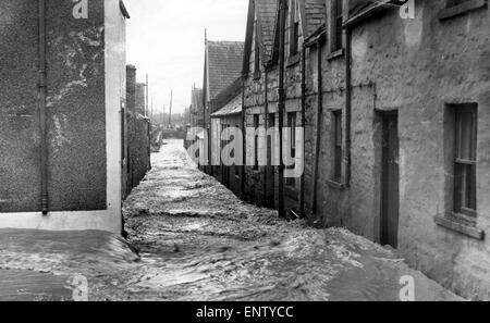 Il solo suono è il crudo e raffinati dell'acqua, in una delle strade deserte del Creetown, in Dumfries and Galloway (Scozia ad ovest del Sud), sul lato nord del Solway Firth, 10 novembre 1954. Foto Stock