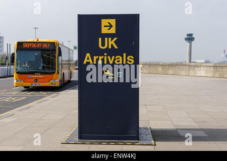 Bus navetta e cartello Arrivi presso l'aeroporto di Londra Stansted Essex Inghilterra Regno Unito Foto Stock